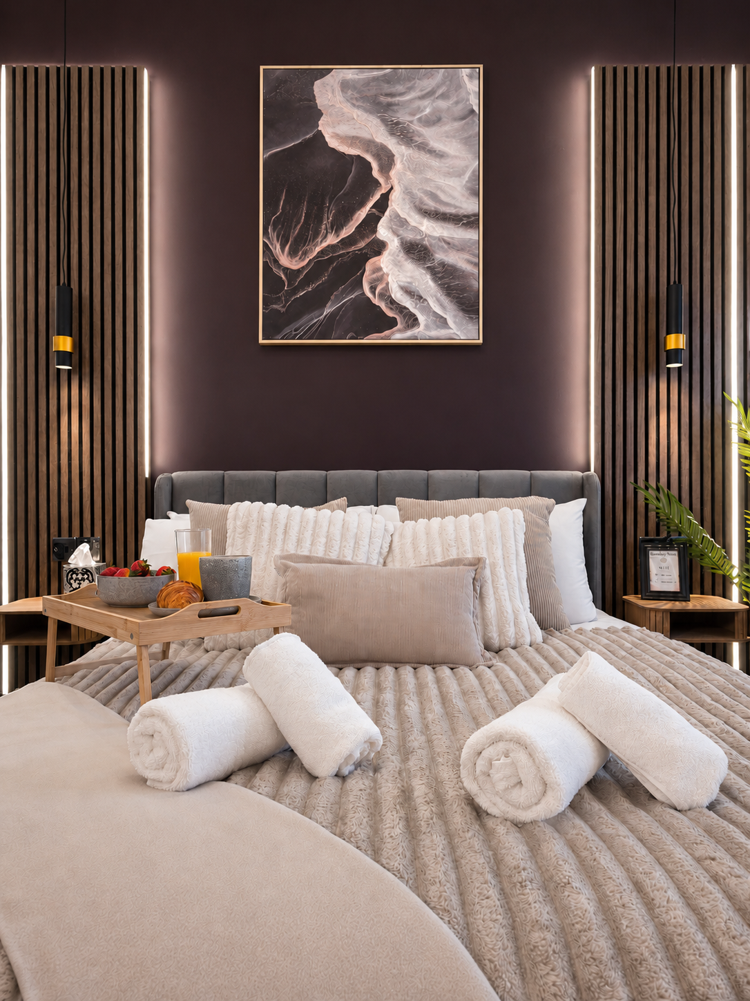 bromley-bedroom-feature-wall-hotel-style-comfort Luxury bedroom in a Bromley serviced apartment featuring a king-size bed, hotel-quality bedding and ambient feature lighting.