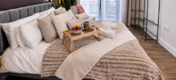 bromley-bedroom-large-window-bright-comfort Stylish bedroom in a Bromley serviced apartment featuring a king-size bed, dedicated workspace and natural light, ideal for business and longer stays